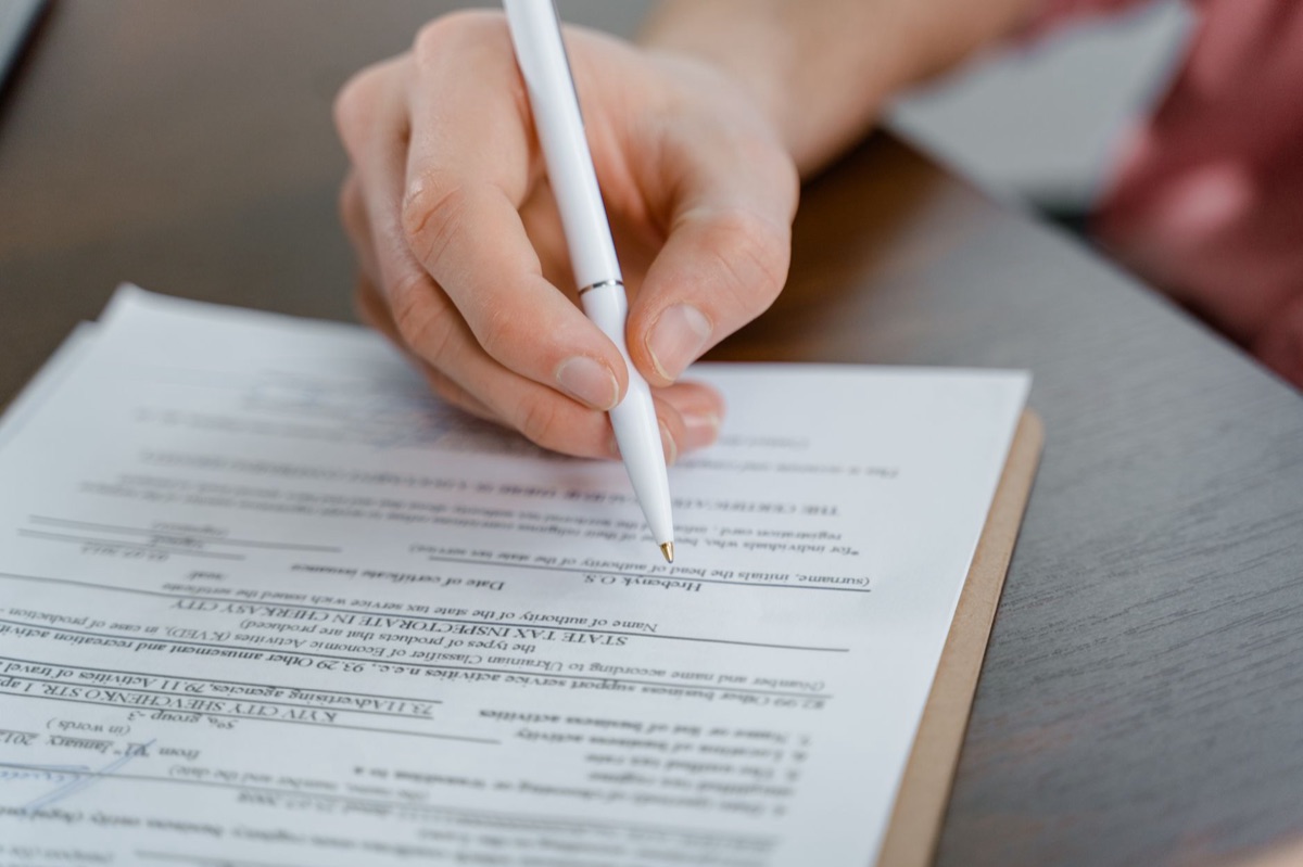 Detaillierter Bauvertrag mit Stift auf dem Tisch