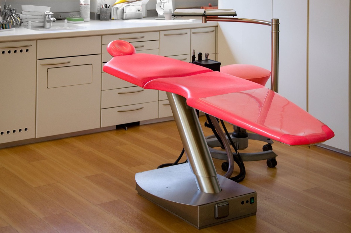 Modern medical office interior with white walls, neutral furniture, and a reception desk with a digital screen displaying 'Best Specialists'
